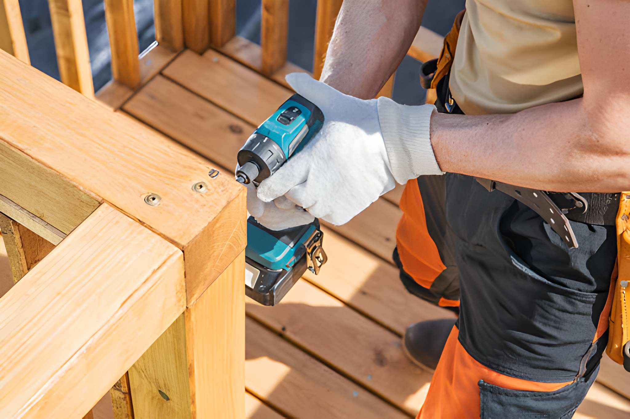 Contractor repairing deck railing with power drill during maintenance and repairs and home maintenance and repair project