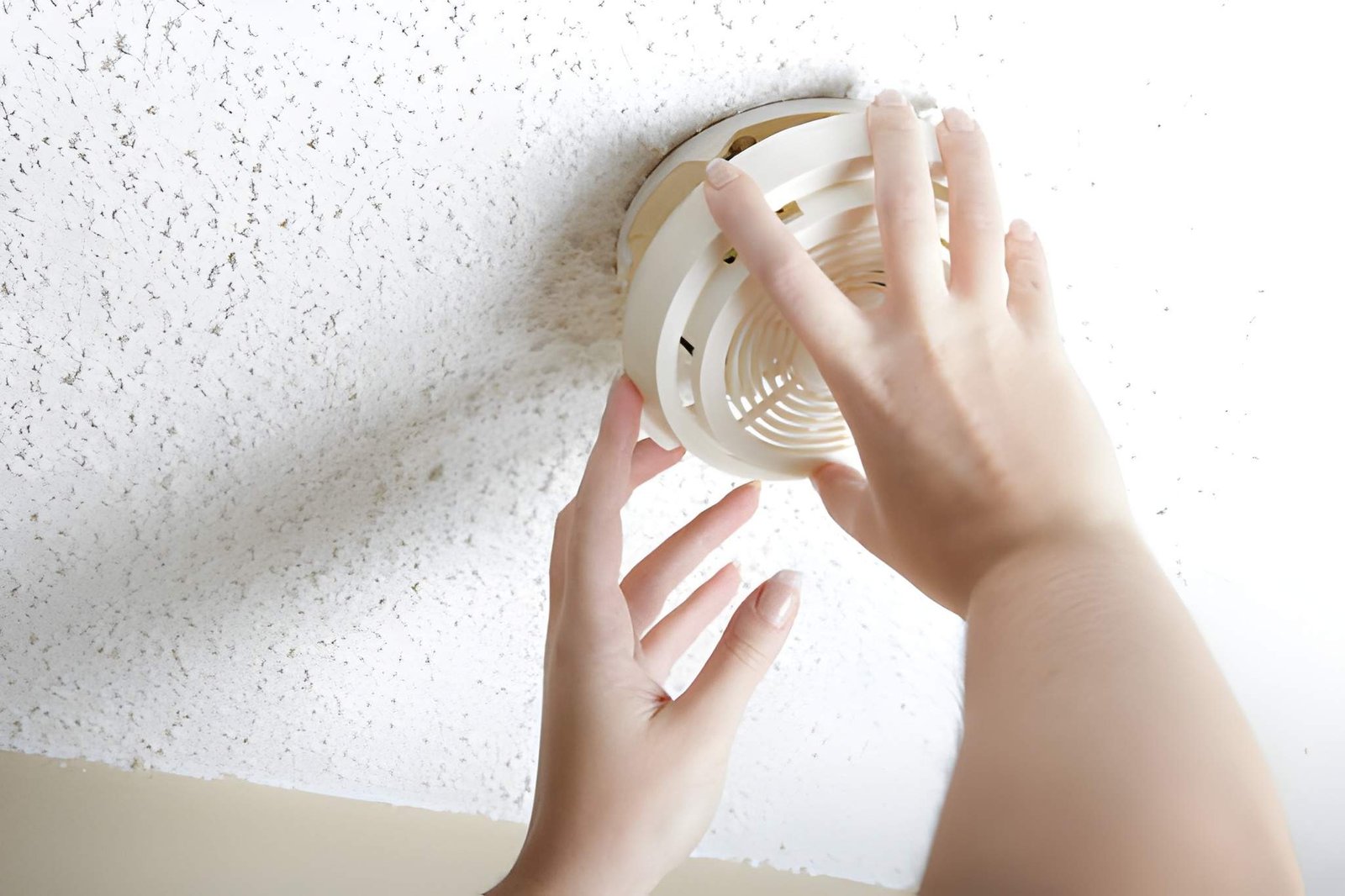 Technician testing a smoke detector in a Phoenix rental unit